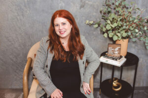 Smiling woman seated indoors, calm setting reflecting early signs of emotional burnout and quiet exhaustion