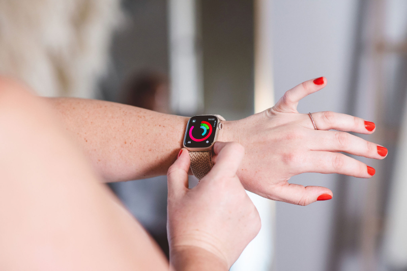 Person adjusting smartwatch on wrist, tracking activity and daily habits with wearable device