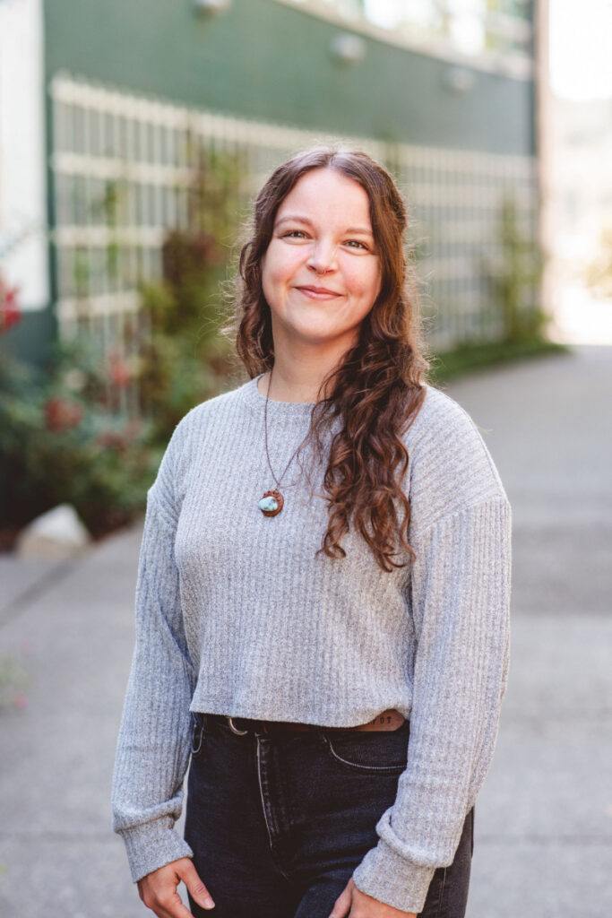 Woman smiling outdoors while discussing setting boundaries with coworkers and protecting mental health at work.