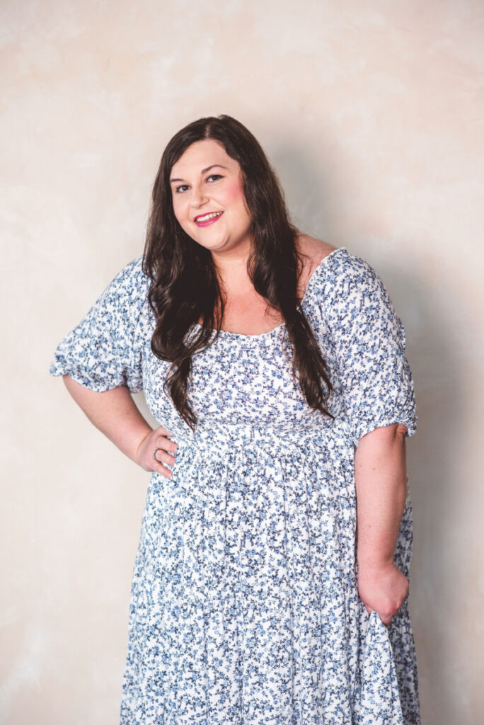 Female counsellor smiling against a neutral background for a blog about emotionally focused family therapy and building stronger family connections.