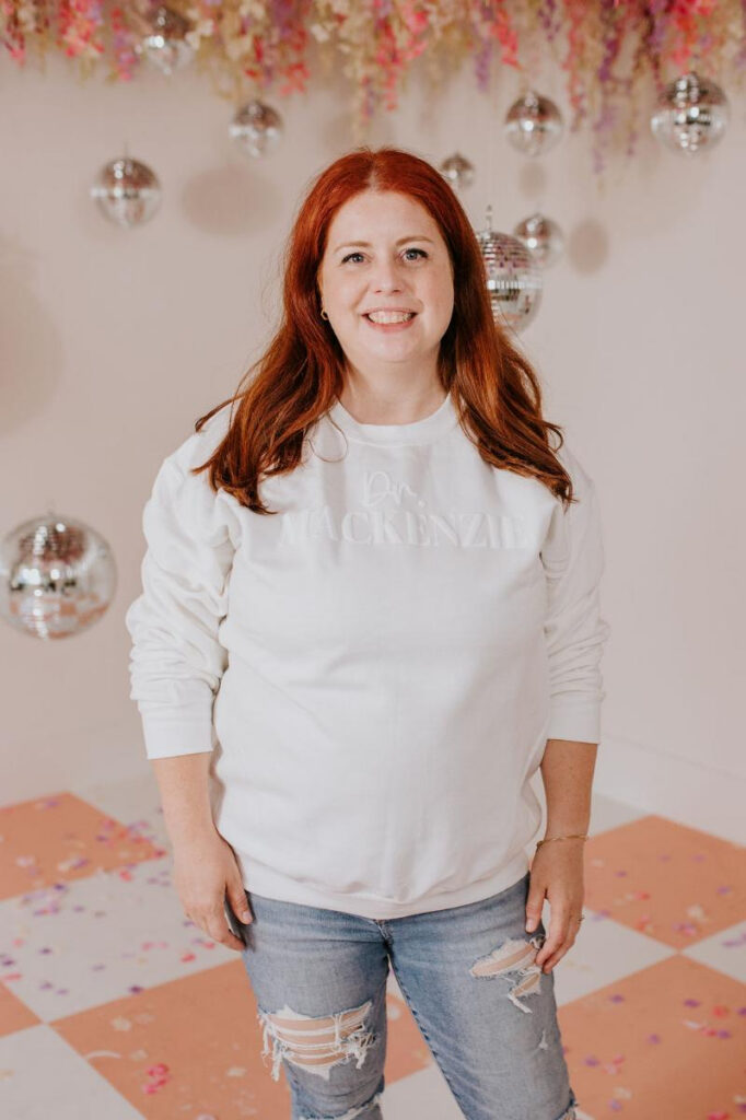 Smiling woman in a white sweater representing hope and confidence during eating disorder recovery.